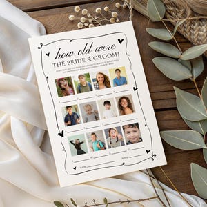 May include: A cream-colored wedding game card with the text "how old were THE BRIDE & GROOM?" and spaces for guests to guess the ages of people in photos. The card is decorated with hearts and swirls.