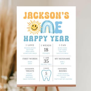 Może przedstawiać: Spersonalizowany znak 'Happy Year' z 'Jackson's', słońcem i tęczą. Zawiera wagę (8,16 kg), wzrost (88,9 cm) i preferencje. Prezentowany na miedzianym sztaludze.