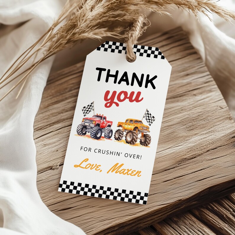 Puede incluir: Una etiqueta de regalo blanca con un borde a cuadros blanco y negro y una cuerda de hilo. La etiqueta dice "THANK YOU" en negro y rojo, con una ilustraci&oacute;n de acuarela de dos monster trucks. Tambi&eacute;n se incluye el texto "FOR CRUSHIN' OVER! Love, Maxen".