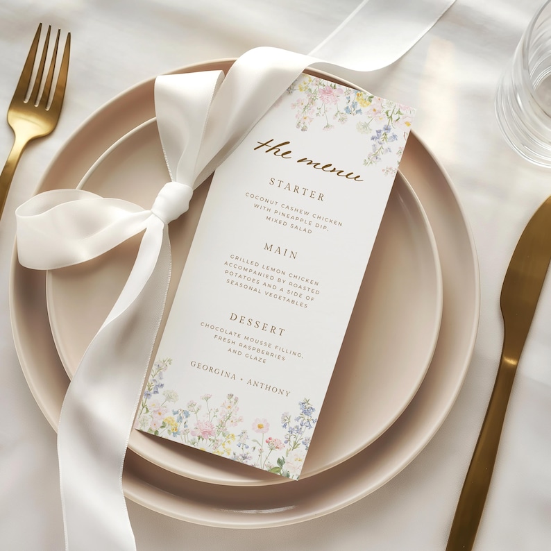 May include: A white rectangular menu card with floral illustrations at the top and bottom, featuring the text the menu, starter, main, dessert, and the names Georgina and Anthony, tied with a white satin ribbon on a light pink plate.