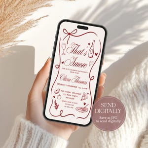 May include: A smartphone displays a digital invitation with the text "That's Amore" in a decorative font. The invitation includes event details, illustrations, and a call to send digitally.