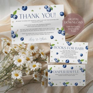 May include: A set of baby shower stationery with a blueberry theme. The design includes a thank you card, a book request card, and a diaper raffle card. The cards feature watercolor blueberries and text. A bouquet of white daisies is in the foreground.