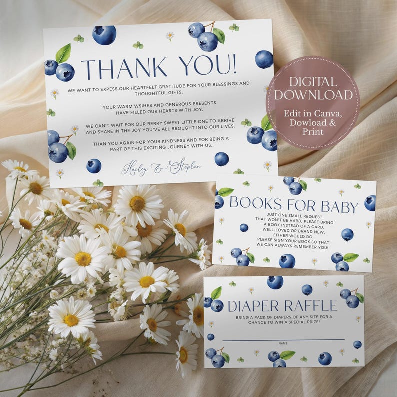 May include: A set of baby shower stationery with a blueberry theme. The design includes a thank you card, a book request card, and a diaper raffle card. The cards feature watercolor blueberries and text. A bouquet of white daisies is in the foreground.