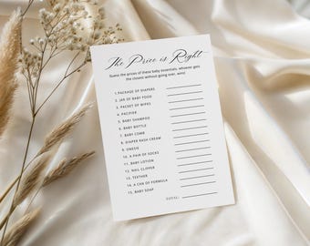 Puede incluir: Una tarjeta blanca con el texto "The Price is Right" y una lista de artículos esenciales para bebés. La tarjeta está sobre una tela color crema con flores secas en el fondo. El juego consiste en adivinar los precios de los artículos para bebés.