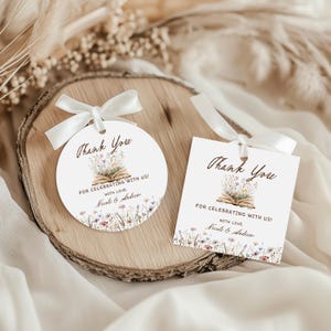 May include: Two white gift tags with a floral design and the text "Thank You". One tag is round, the other square. Both have a white ribbon and the text "For Celebrating With Us!" and names.