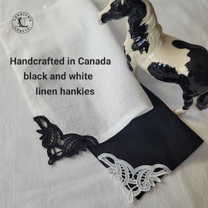 May include: Two linen handkerchiefs, one white and one black, with decorative lace trim. The white handkerchief has black lace, and the black handkerchief has white lace. A black and white horse figurine is also present. Text on the image reads: Handcrafted in Canada black and white linen hankies.