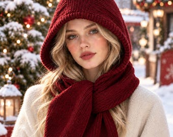 Peut inclure: Une écharpe à capuche en tricot rouge profond avec une texture côtelée. L'accessoire se compose d'une capuche reliée à de longues extrémités d'écharpe, fabriquée dans un fil épais et chaud. Le design offre une couverture complète.
