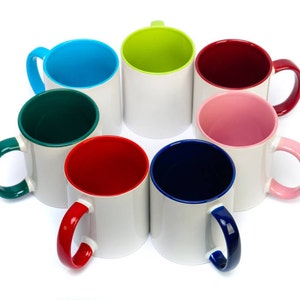 K&ouml;nnte beinhalten: Acht Keramikbecher mit wei&szlig;em &Auml;u&szlig;eren und farbigem Inneren. Die Becher sind in einem Kreis angeordnet, wobei die Henkel nach au&szlig;en zeigen. Die Farben der Becher sind blau, gr&uuml;n, rot, rosa, marineblau, lindgr&uuml;n und kastanienbraun.