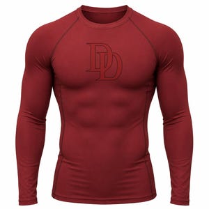 Puede incluir: Una camiseta de compresión de manga larga color granate con cuello redondo y mangas raglán. La camiseta presenta un logotipo de doble "D" en rojo oscuro en el pecho. La camiseta está diseñada para un ajuste ceñido.