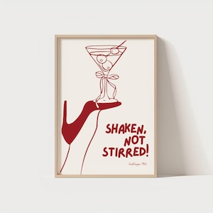 May include: A red illustration of a martini glass with olives, held by a red hand, with the text "SHAKEN, NOT STIRRED!" and "Goldfinger 1964" below.