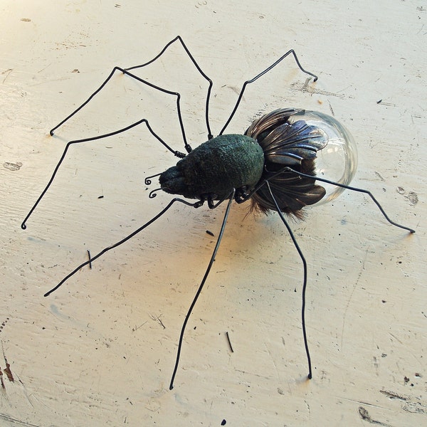 Green velvet sculpture of a spider with glass compartment for secrets....