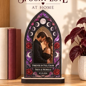 May include: An arched acrylic plaque featuring a stained glass-style border with purple hues, moon phases, and red roses. The center displays a photograph of a couple, with the text "FOREVER IN FULL COLOR," "FREYA & NICHOLAS," and "07.25.2026."