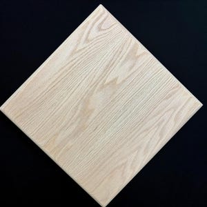 May include: A light wood square tile with a natural wood grain pattern.