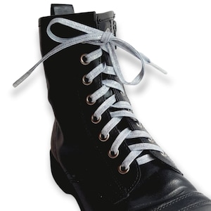 May include: Black leather ankle boots with silver laces. The laces are tied in a bow at the top of the boot.