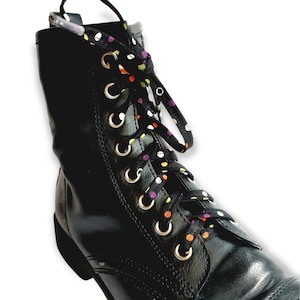 May include: Black leather boots with colorful polka dot shoelaces. The laces are black with white, orange, yellow, and purple polka dots.