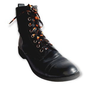 May include: Black leather combat boots with orange and white patterned laces.