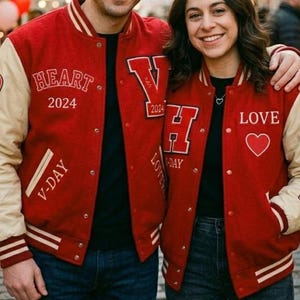 May include: Red and cream varsity jackets with various patches and text. One jacket says "HEART 2024" and "V-DAY", the other says "LOVE" and "FEB 14". Both have heart patches. The jackets are worn by a couple.