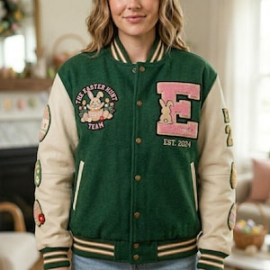 May include: Green and cream varsity jacket with Easter-themed patches. The jacket features a large pink letter "E" with a bunny and the text "EST. 2024". Additional patches include a bunny with the text "THE EASTER HUNT TEAM".