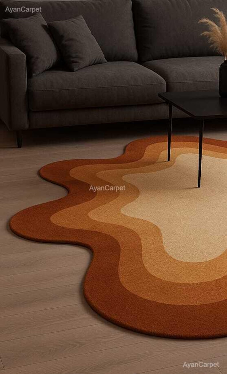 May include: A wavy, abstract area rug with a multi-colored design in shades of brown, orange, and beige. The rug is made of a soft, plush material and has a unique, organic shape.