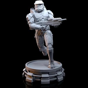 以下が含まれることがあります： 武器を持った未来的な兵士の白いプラスチック製フィギュア。テクスチャ加工されたデザインの円形ベースの上に立っている。