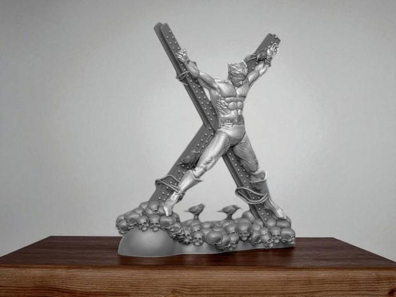 May include: A silver-colored sculpture of a superhero figure attached to a large X-shaped structure. The base of the sculpture is adorned with skulls and small bird figures. The sculpture is displayed on a wooden surface.