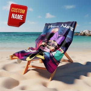 Pu&ograve; includere: Un telo mare con un personaggio dei cartoni animati con occhiali da sole e un fiocco viola, sullo sfondo di un tramonto tropicale. L'asciugamano &egrave; drappeggiato su una sedia a sdraio di legno su una spiaggia sabbiosa. Il testo "Your Name" &egrave; visibile sull'asciugamano e un'etichetta rossa dice "Custom Name".