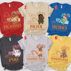 May include: Six short-sleeved t-shirts in red, beige, blue, dark gray, light gray, and yellow. Each shirt features a character graphic from the movie Moana, the year 2016, and the character's name printed in a stylized font with palm tree accents.