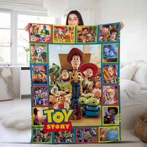 May include: A rectangular fleece blanket featuring a collage of Toy Story characters. The center displays Woody, Buzz Lightyear, Jessie, and the Aliens. Smaller panels surround the main image, showcasing various scenes and characters from the film.