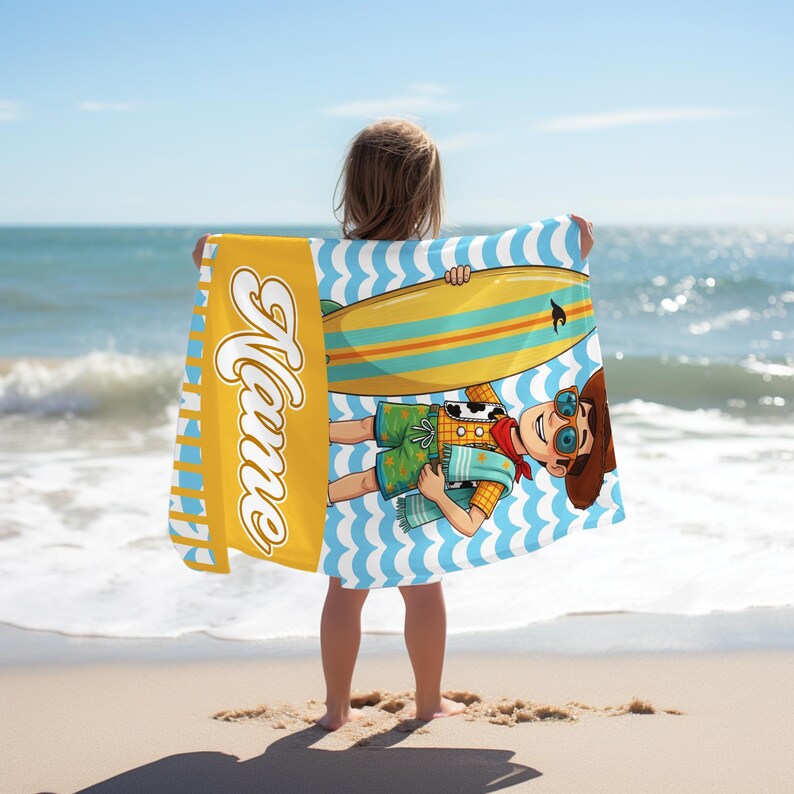 May include: A rectangular beach towel featuring a cartoon character wearing a cowboy hat, sunglasses, and a patterned shirt, holding a yellow surfboard. The design includes a vertical yellow stripe with the white cursive text Name.