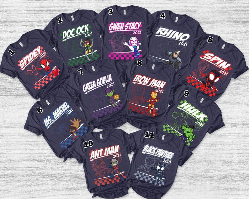Pode incluir: Uma cole&ccedil;&atilde;o de onze camisetas azul-marinho escuro, cada uma com um gr&aacute;fico de personagem Marvel &uacute;nico, o nome do personagem e o ano 2021. Os personagens incluem Spidey, Doc Ock, Gwen Stacy, Rhino, Spin, Ms. Marvel, Green Goblin, Iron Man, Hulk, Ant Man e Black Panther.