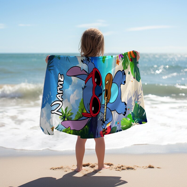 May include: A blue beach towel featuring a cartoon character wearing red sunglasses and holding a ukulele. The towel has a tropical background with the word "Name" in a script font. The towel is held up on a sandy beach.