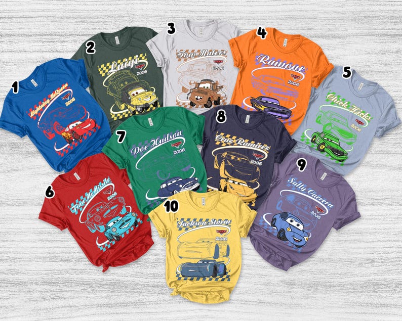 May include: A collection of ten short-sleeved t-shirts in various colors, each featuring a unique character from the movie Cars, including Lightning McQueen, Luigi, Tow Mater, Ramone, Chick Hicks, Finn McMissile, Doc Hudson, Cruz Ramirez, Sally Carrera, and Jackson Storm.