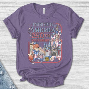 Puede incluir: Una camiseta morada con un gr&aacute;fico que conmemora el 250 aniversario de los Estados Unidos de Am&eacute;rica. El dise&ntilde;o incluye personajes de dibujos animados, un castillo e im&aacute;genes patri&oacute;ticas.