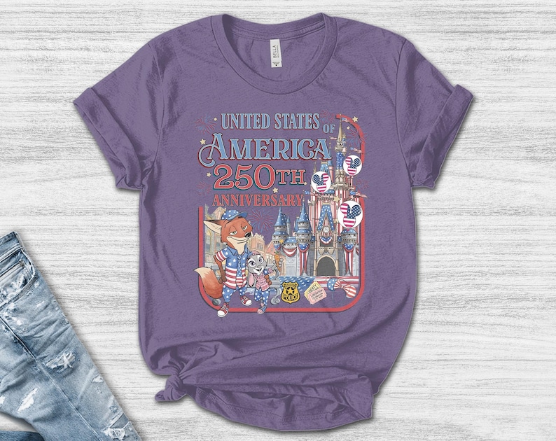 Puede incluir: Una camiseta morada con un gr&aacute;fico que conmemora el 250 aniversario de los Estados Unidos de Am&eacute;rica. El dise&ntilde;o incluye personajes de dibujos animados, un castillo e im&aacute;genes patri&oacute;ticas.