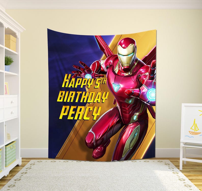 Puede incluir: Un tapiz de Iron Man rojo y dorado con el texto "Happy 5th Birthday Percy". El superh&eacute;roe est&aacute; en una pose din&aacute;mica sobre un fondo azul y dorado. Ideal para una fiesta de cumplea&ntilde;os infantil o la decoraci&oacute;n de un dormitorio.