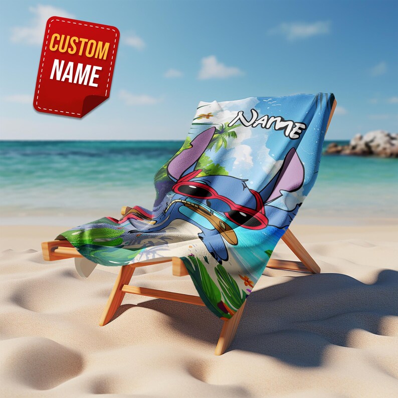 May include: A beach chair with a blue and white beach towel featuring a cartoon character wearing red sunglasses. The towel has the word "Name" on it. A red tag with the words "Custom Name" is in the upper left corner.