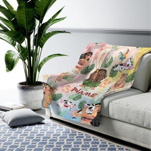 Puede incluir: Una colorida manta con personajes de dibujos animados y elementos tropicales. La manta muestra varios personajes, flores y la palabra "NAME" en una fuente l&uacute;dica. El dise&ntilde;o est&aacute; sobre un fondo pastel.