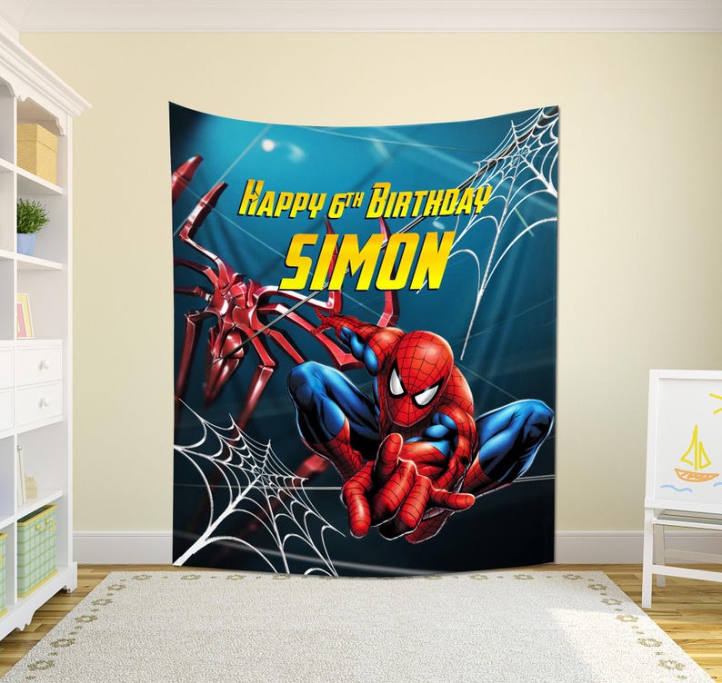 May include: A large wall tapestry featuring Spider-Man in a dynamic pose, with a red and blue costume. The background is a gradient of blue. Text reads "Happy 6th Birthday Simon" in yellow. A spider web design is also present.