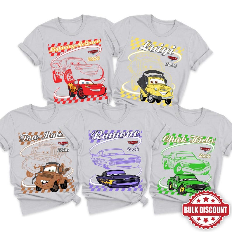 May include: Five light gray t-shirts featuring Disney Pixar Cars characters Lightning McQueen, Luigi, Tow Mater, Ramone, and Chick Hicks. Each shirt displays a character illustration, their name, the year 2006, and a checkered border pattern.