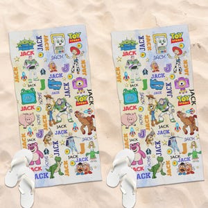 May include: Two white beach towels with a colorful Toy Story design featuring characters like Buzz Lightyear and Woody, along with the word "JACK". White flip-flops are at the bottom of each towel.