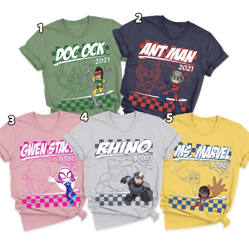 Pode incluir: Cinco camisetas de manga curta em verde oliva, azul marinho, rosa claro, cinza claro e amarelo. Cada camiseta apresenta um gr&aacute;fico de personagem da Marvel, uma borda xadrez, o nome do personagem e o ano 2021. Os personagens incluem Doc Ock, Ant Man, Gwen Stacy, Rhino e Ms. Marvel.