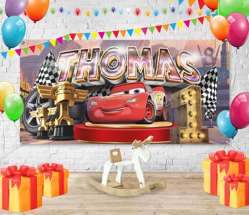 May include: A birthday party scene with a banner that says "THOMAS" and features a red race car. The scene includes balloons, checkered flags, golden trophies, and wrapped gifts. A wooden rocking horse and a light-up number one are also present.