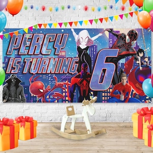 May include: A birthday banner featuring Spider-Man characters and the text PERCY IS TURNING 6, surrounded by colorful balloons and bunting. In the foreground, a white wooden rocking horse sits between two yellow gift boxes with red ribbons.