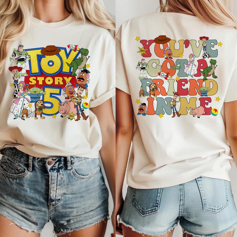 K&ouml;nnte beinhalten: Cremefarbenes T-Shirt mit dem Toy Story 5 Logo auf der Vorderseite und dem Schriftzug "You've Got a Friend in Me" auf der R&uuml;ckseite. Das Design zeigt verschiedene Toy Story Charaktere in einem bunten Cartoon-Stil.