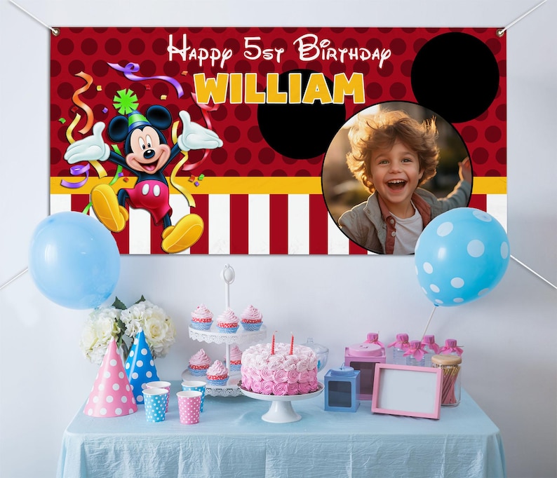 Może przedstawiać: Scena przyjęcia urodzinowego z banerem z Myszka Miki i napisem "Happy 5th Birthday WILLIAM". Baner ma czerwone tło w kropki. St&oacute;ł jest nakryty ciastem, babeczkami, balonami i czapeczkami.