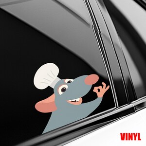 Puede incluir: Una rata de dibujos animados con un gorro de chef, haciendo el gesto de la mano de 'ok'. La rata es gris con la nariz y las orejas rosas. La palabra 'VINYL' est&aacute; impresa en rojo en la parte inferior derecha. La pegatina est&aacute; en la ventana de un coche.