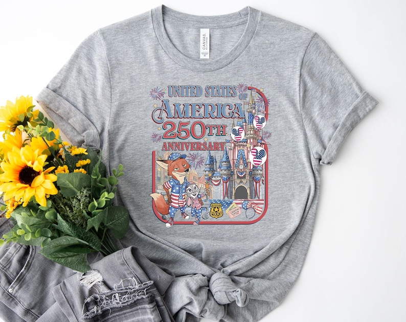Puede incluir: Camiseta gris jaspeado con un gr&aacute;fico colorido que celebra el 250 aniversario de los Estados Unidos de Am&eacute;rica. El dise&ntilde;o incluye un zorro y un conejo de dibujos animados, un castillo y fuegos artificiales. La camiseta es de material suave.