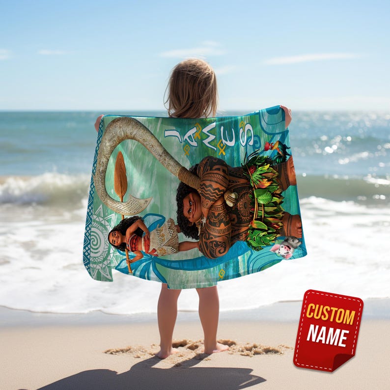 May include: A beach towel with characters from an animated film. The towel has a teal and blue background with illustrations of characters and a large hook. The words "Sea Way" are printed on the towel. A red tag with the words "Custom Name" is visible.