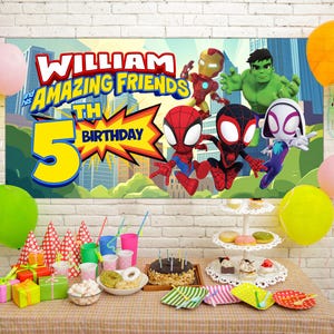 Puede incluir: Una escena de fiesta de cumplea&ntilde;os con una pancarta con personajes de superh&eacute;roes y el texto "WILLIAM and his AMAZING FRIENDS 5th BIRTHDAY." Globos de colores, art&iacute;culos de fiesta, un pastel y golosinas est&aacute;n colocados sobre una mesa.