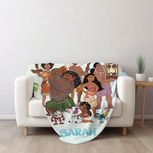 May include: A light blue fleece blanket featuring a colorful graphic print of animated characters including a large tattooed man, a young woman, a pig, and a rooster. The name SARAH is printed in large blue letters at the bottom of the blanket.